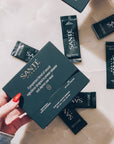 Hands holding Sante product packaging on a light surface
